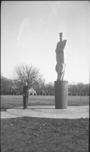 Mennonite Settler statue, with an adult man standing in front of it
